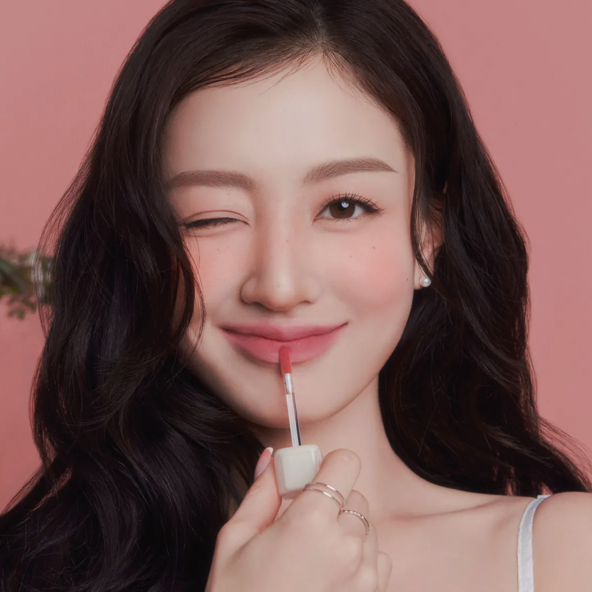 Woman applying MILK TOUCH Spread Fit Blur Tint with a smile