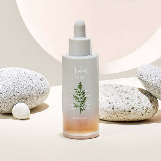 MISSHA Artemisia soothing ampoule 50ml displayed with natural stones in background.