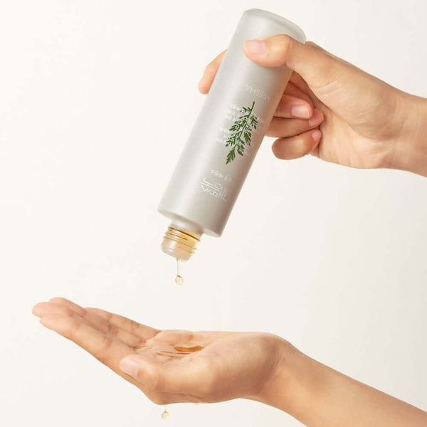 Person pouring MISSHA Artemisia Soothing Essence 150ml into hand, highlighting its texture and soothing benefits.