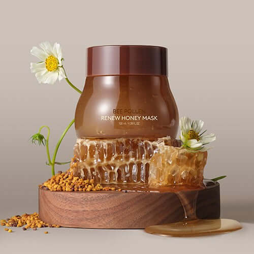 MISSHA Bipolen Renew Honey Mask 130ml jar with honey and flowers displayed elegantly on a wooden platform.