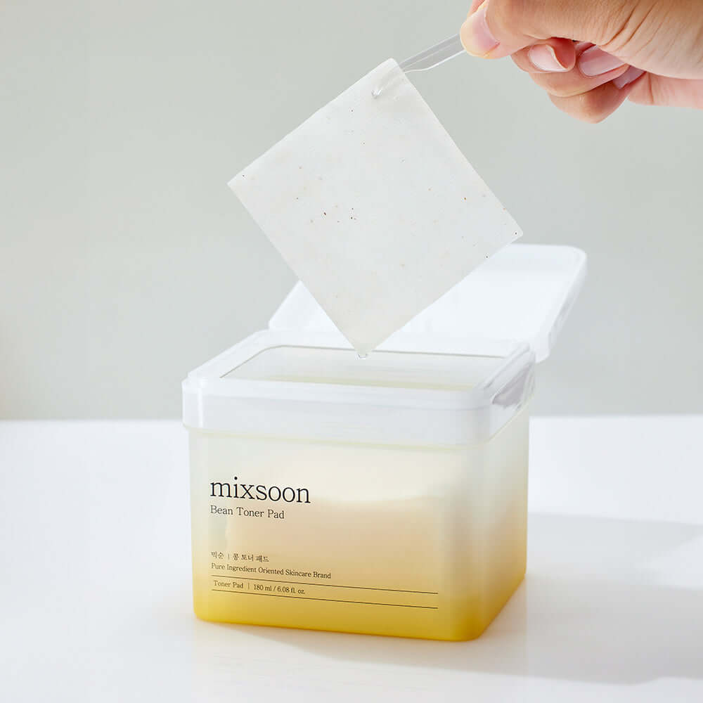 MIXSOON Bean Toner Pad being lifted from container, showcasing its texture.