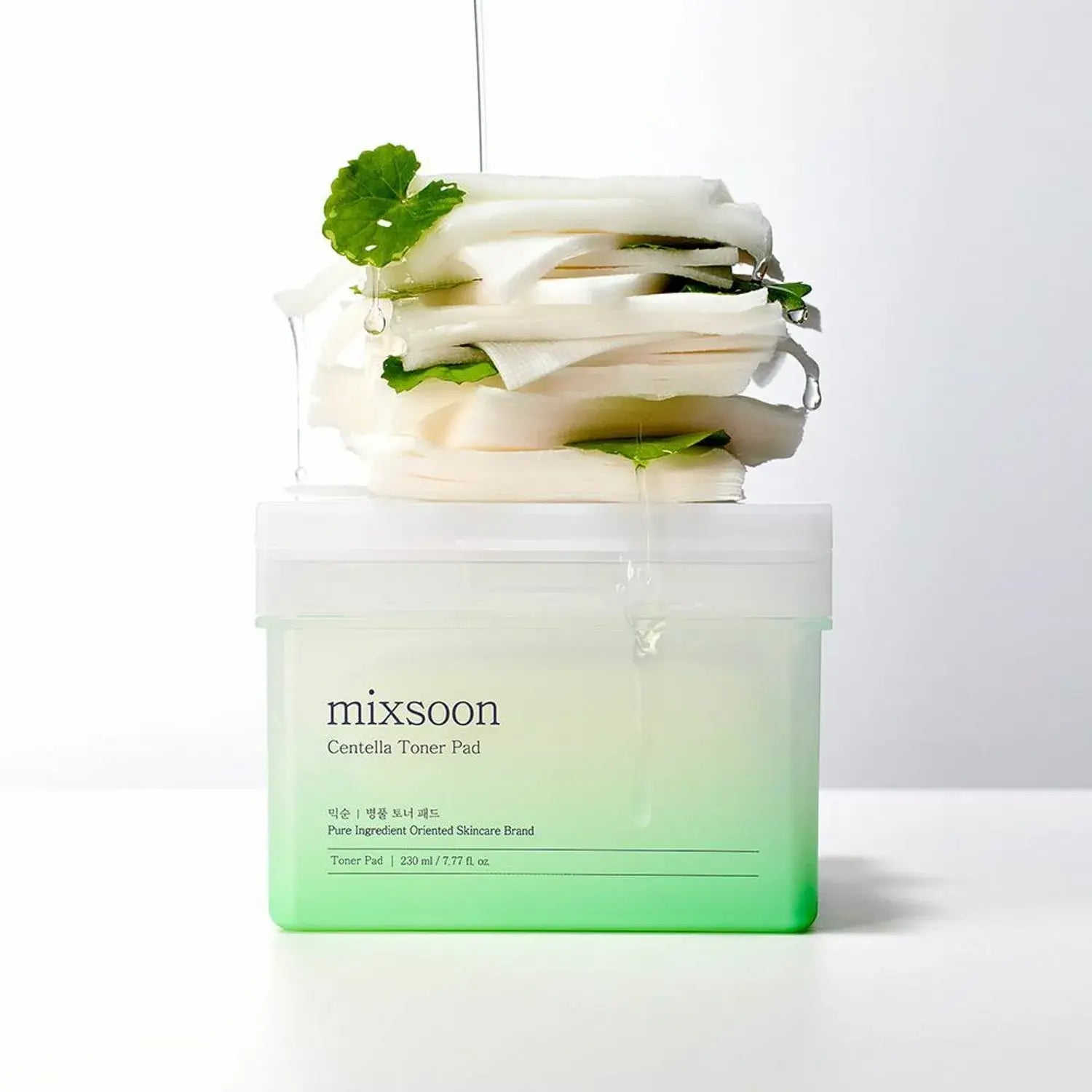 MIXSOON Bottle Grass Toner Pad stacked with cotton pads, infused with natural extracts for skin care.