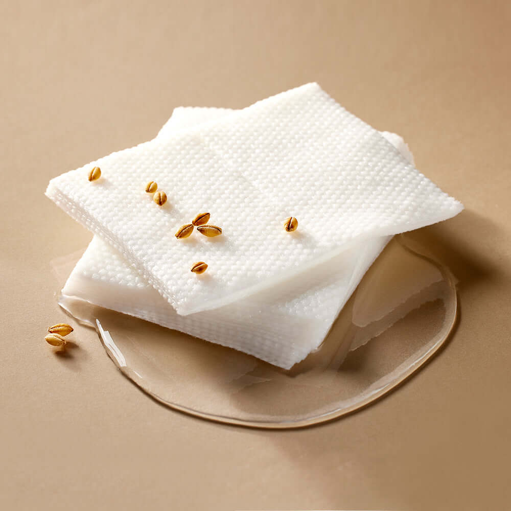 MIXSOON Galactomyces Toner Pad placed on a beige surface with grains and liquid