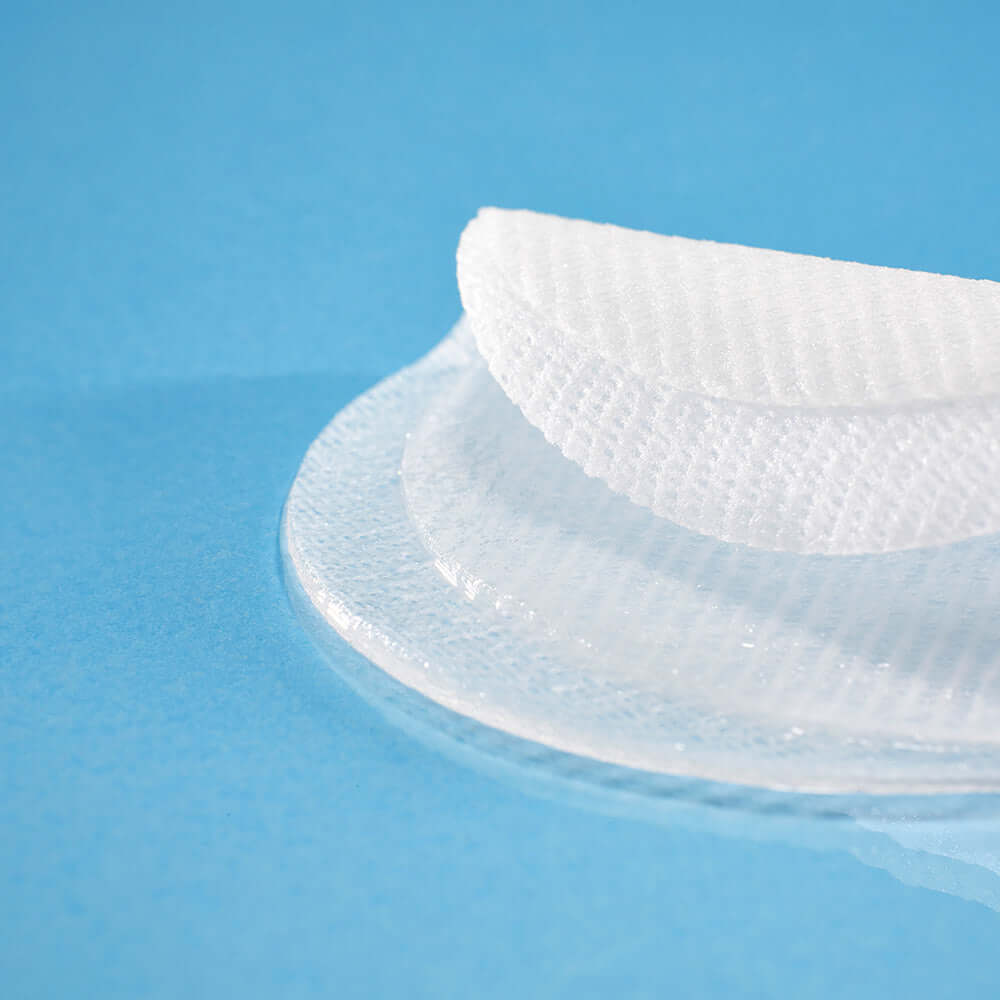 Close-up of MIXSOON Hyaluronic Acid Toner Pad on a blue surface, highlighting its texture and quality.