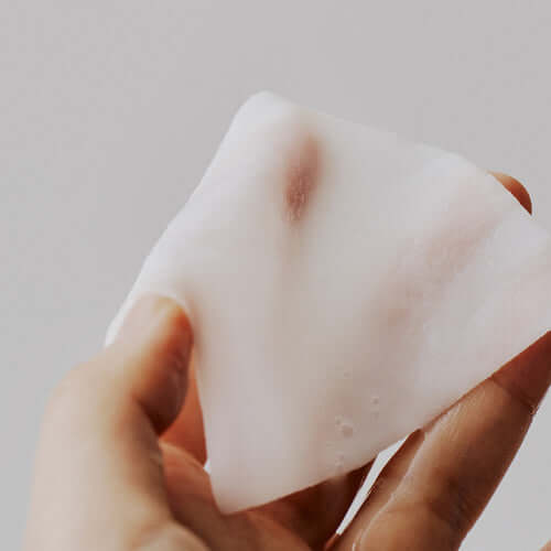 Hand holding a MIXSOON Soybean Milk Pad for skincare