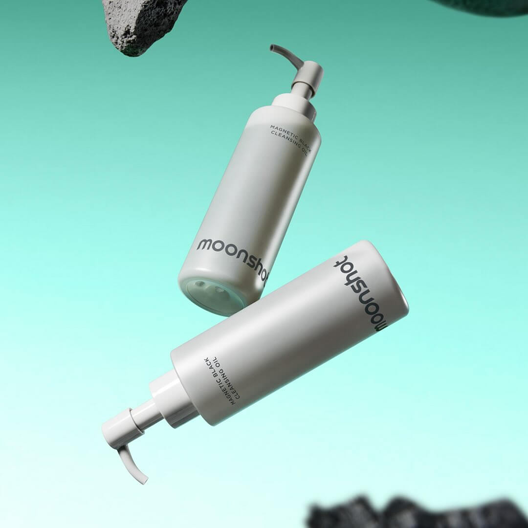 MOONSHOT Megnetic Black Cleansing Oil bottles floating in a turquoise background, displaying the product packaging and branding.