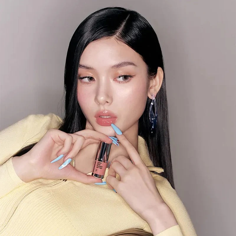 Model showcasing NAMING Overdew Glossy Lip Tint with elegant nail art and sleek hair, highlighting the lip tint's vibrant shade.