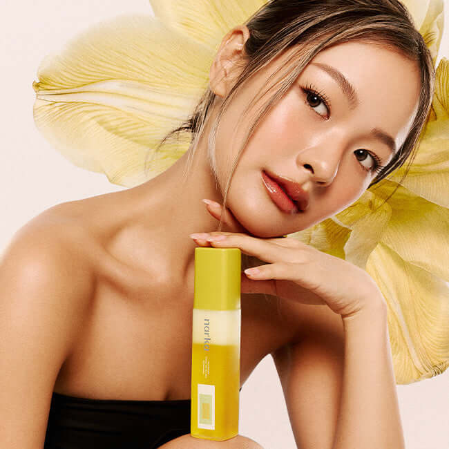 Woman featuring NARKA Creamy Veil Hair Mist with floral background, showcasing its delicate and nourishing properties for shiny hair.