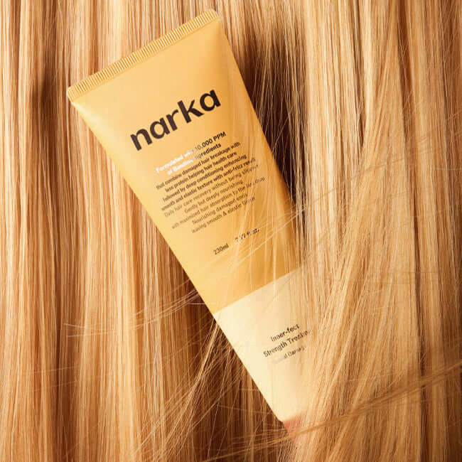 NARKA Innereffect Strength Treatment tube displayed on vibrant blonde hair, promoting hair strength and vitality.