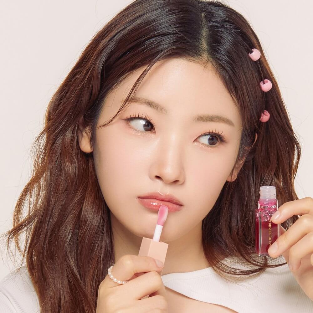Model applying NATURE REPUBLIC Glaze Shine Lip Oil for a glossy finish