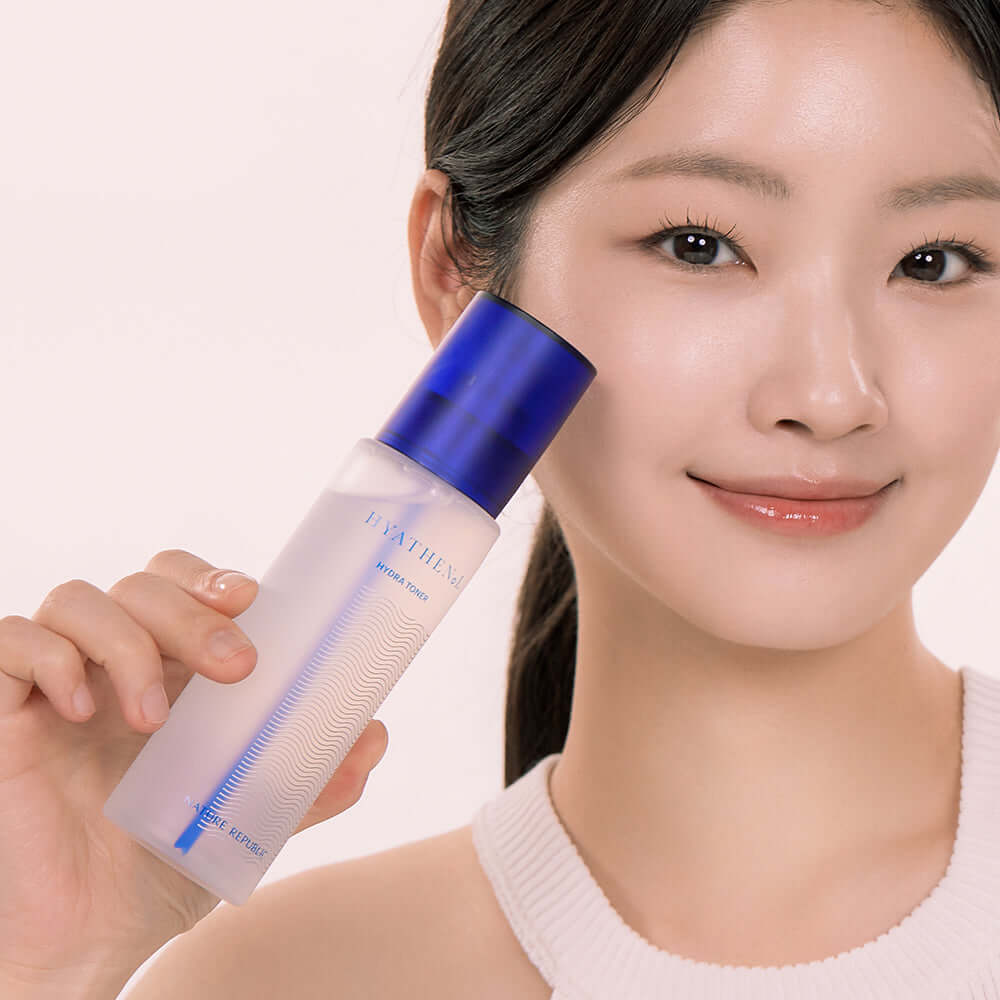Person holding NATURE REPUBLIC Hyathenol Hydra Toner 150ml bottle with blue cap