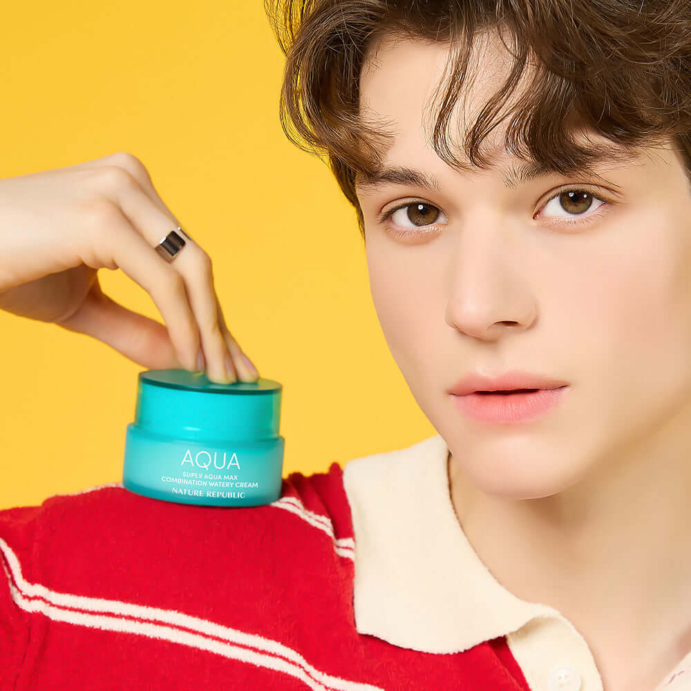 Person holding NATURE REPUBLIC Super Aqua Max Combination Moisture Cream 80ml with yellow background.