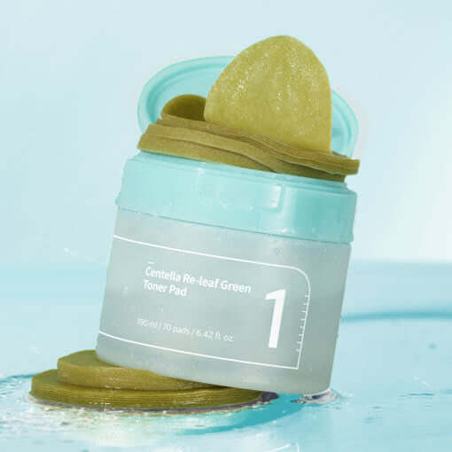 NUMBUZIN No.1 Centella Re-Leaf Green Toner Pad jar with exposed pads against a light blue background.