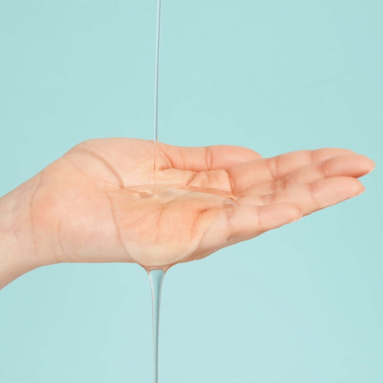 NUMBUZIN No.1 Pantothenic B5 Active Soothing Serum being poured into an open palm against a blue background.