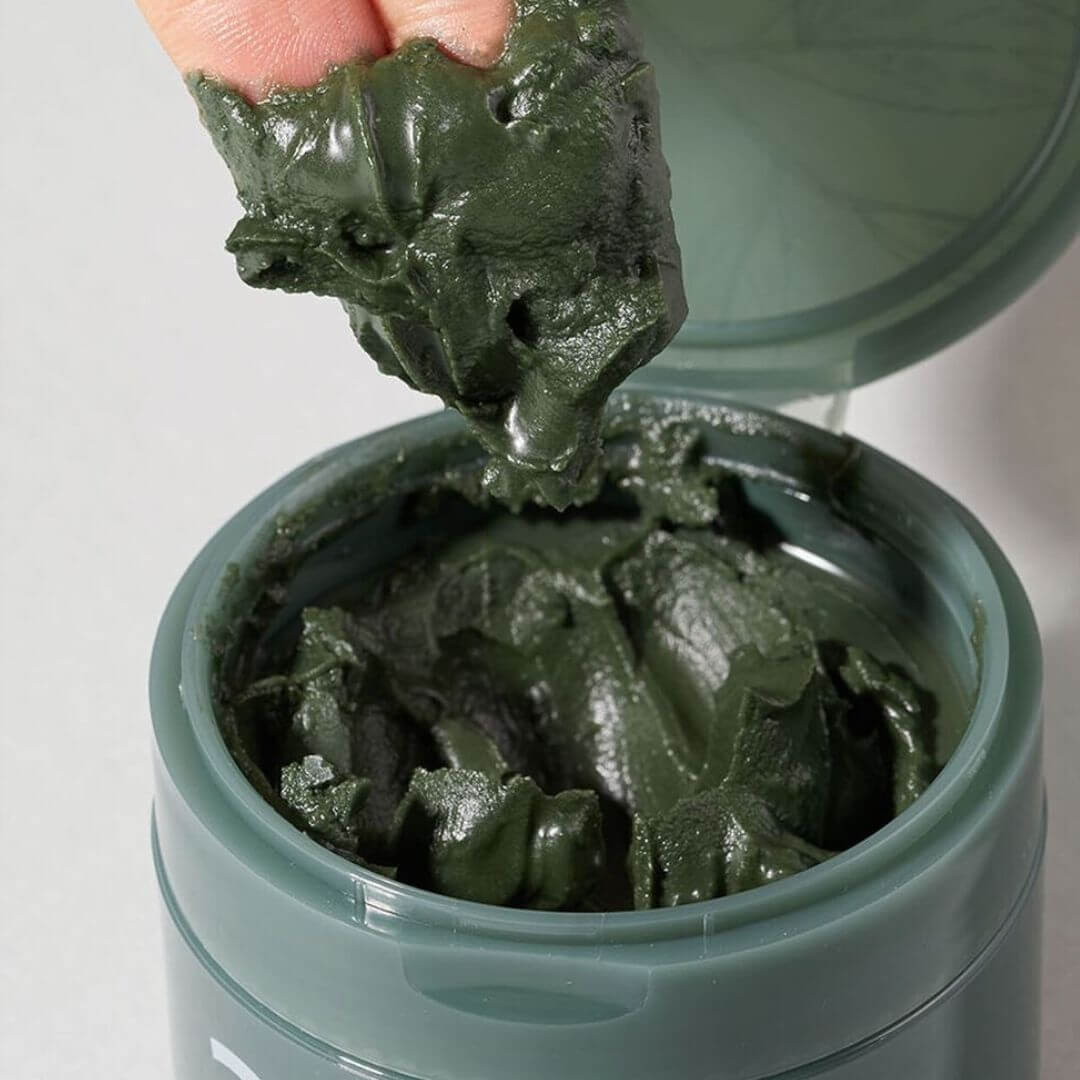 Open jar of NUMBUZIN No.3 Green Tea Charcoal Pore Pack Cleansing Balm with product texture being shown.