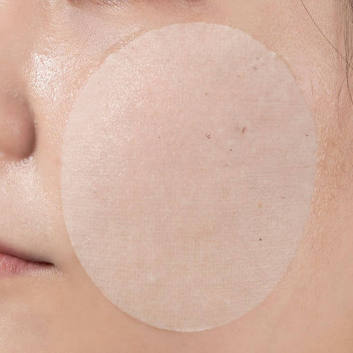 Close-up of skin with NUMBUZIN No.3 Radiance Glowing Jumbo Essence Pad applied for hydration and brightness.