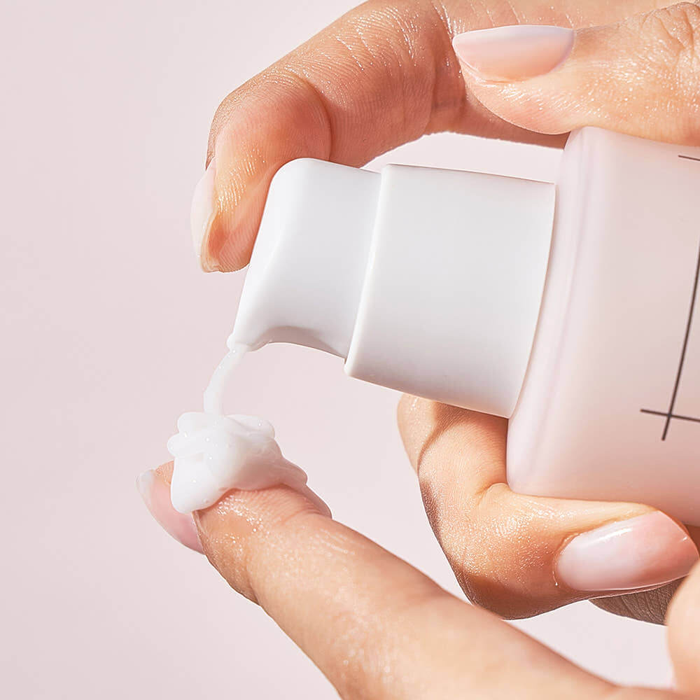 Applying NUMBUZIN No.4 Collagen 73% Pudding Serum to finger with a pump bottle in a skincare routine