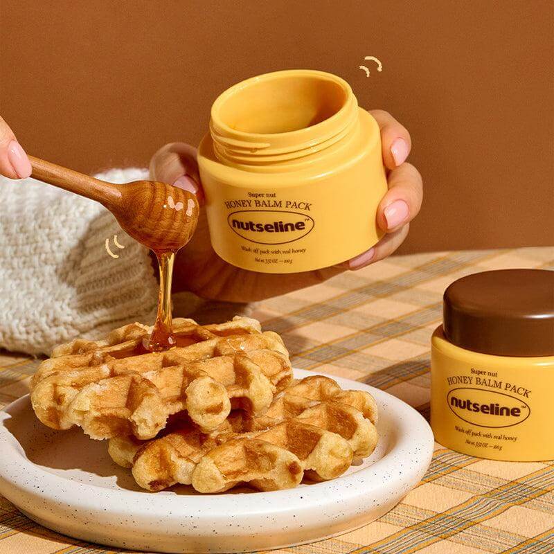 NUTSELINE Super Nut Honey Balm Pack 100g next to waffles and honey dipper.
