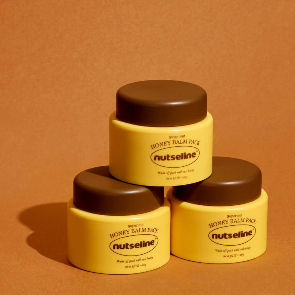 Three jars of NUTSELINE Super Nut Honey Balm Pack 100g stacked on a brown background