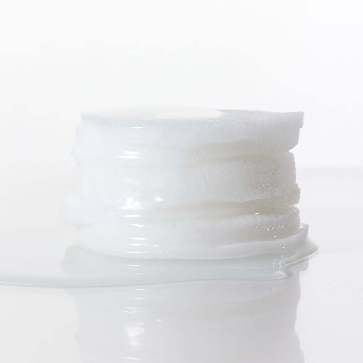 Stack of skincare pads from PARNELL Niacinamide Rice Brightening 60 pads product line on a reflective surface.