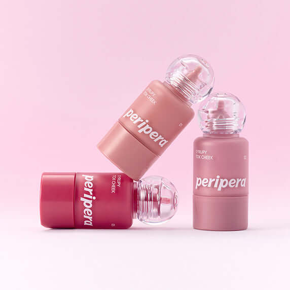 PERIPERA Syruppy Talk Cheek bottles on a pink background. Vibrant lip and cheek tint collection.