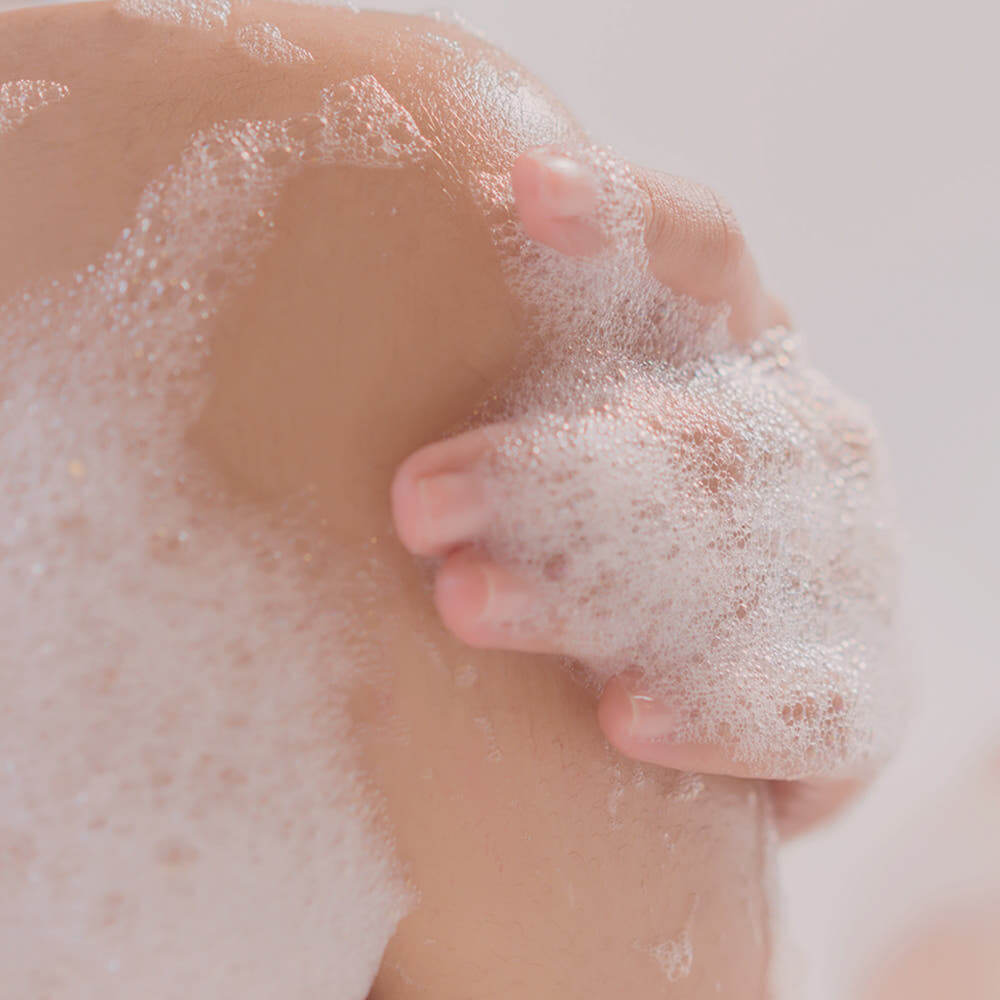 Lather of PYUNKANG YUL Ato Mildly Acidic Moisturizing Body Wash 590ml on skin, showcasing bubbles and gentle cleansing action.