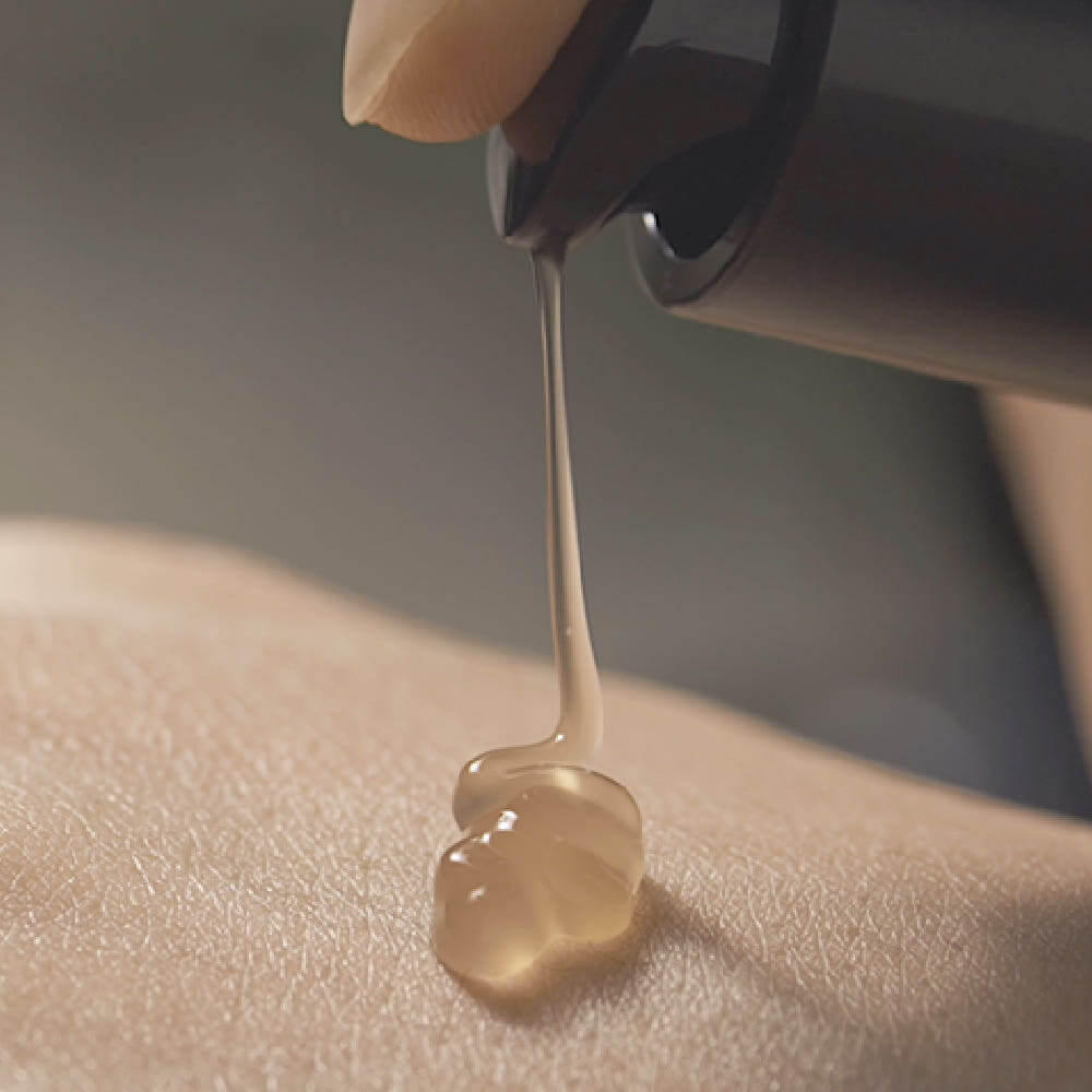 Close-up of PYUNKANG YUL Black Tea Boosting Serum 45ml being dispensed onto skin.