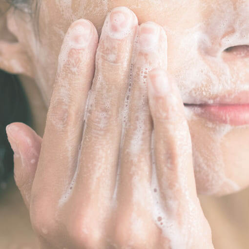Person using PYUNKANG YUL Calming Acne Cleansing Foam 100ml on face, showing gentle foam application.