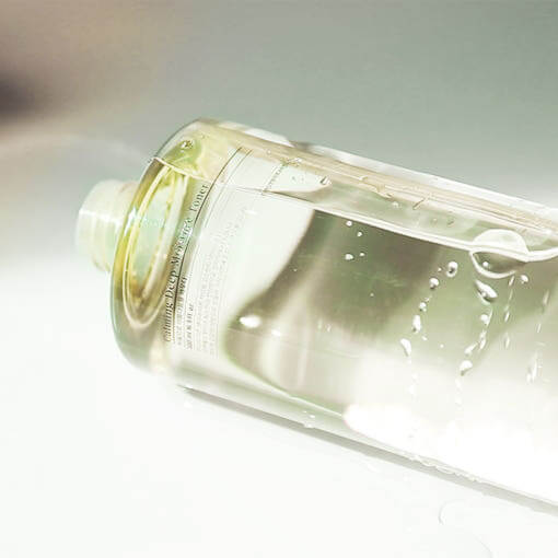 PYUNKANG YUL Calming Deep Moisture Toner 500ml bottle lying sideways, showcasing clear liquid skincare product with a minimalistic design.