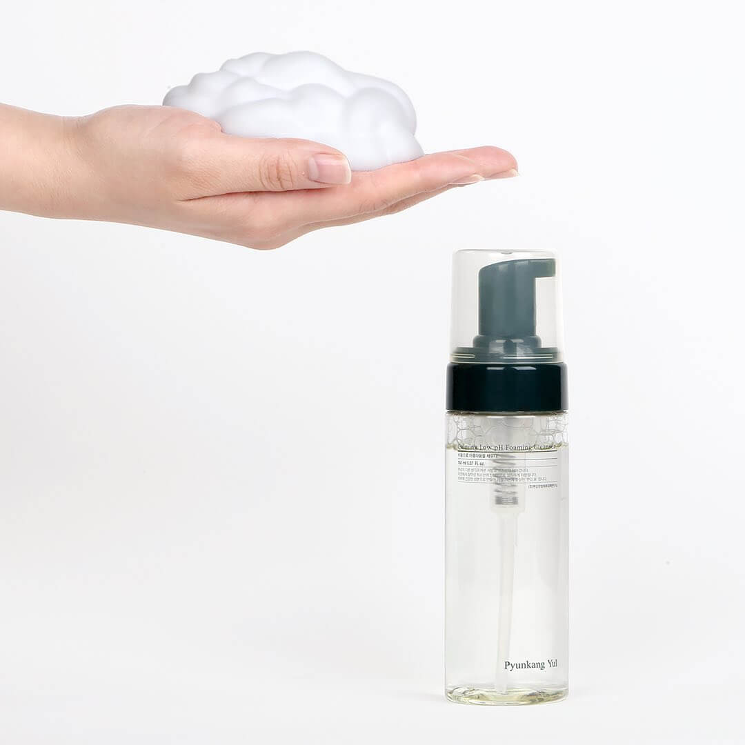 Hand with foam and PYUNKANG YUL Calming Low pH Foaming Cleanser 150ml bottle