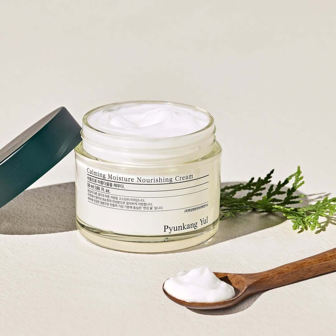 PYUNKANG YUL Calming Moisture Nourishing Cream 50ml jar with cream and a wooden spoon beside it.