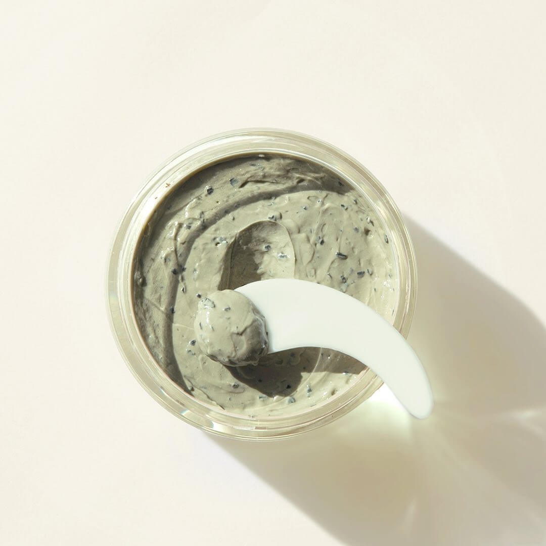 Open jar of PYUNKANG YUL Calming Pore Clear Wash Off Pack 100ml with a spatula on a neutral background.