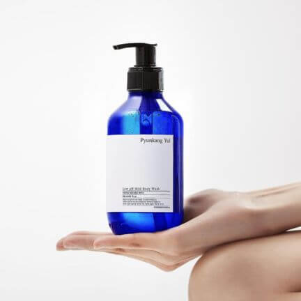 PYUNKANG YUL Low pH Mild Body Wash 500ml bottle on hand, blue container with pump dispenser, moisturizing skincare product