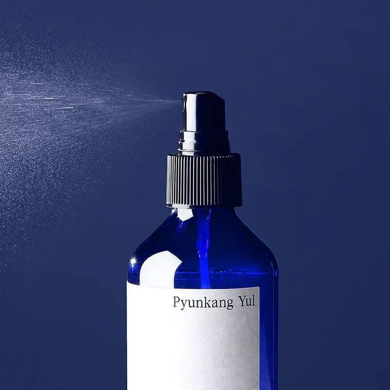 PYUNKANG YUL Mist Toner 200ml bottle spraying fine mist on blue background.