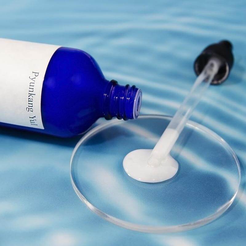 PYUNKANG YUL Moisture Serum 100ml bottle with dropper on blue background