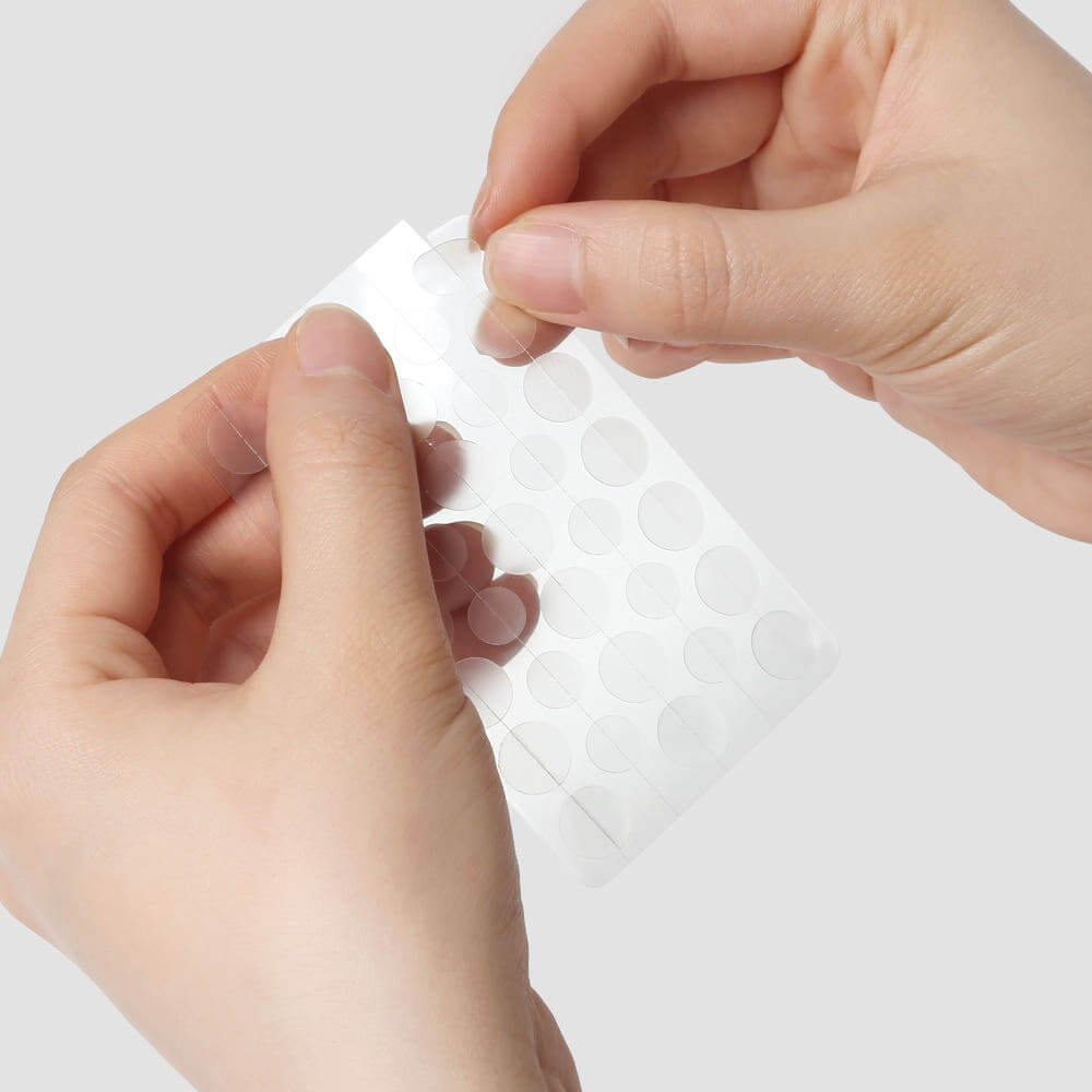 Hands holding PYUNKANG YUL True Clear Spot Patch Intensive Care Vibevel 165 pcs, transparent acne care dots.