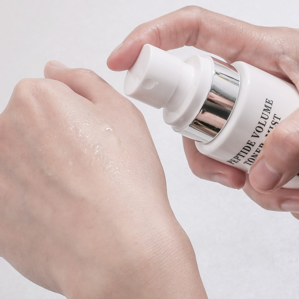 Applying R828 Peptide Volume Toner Mist onto skin for hydration and rejuvenation