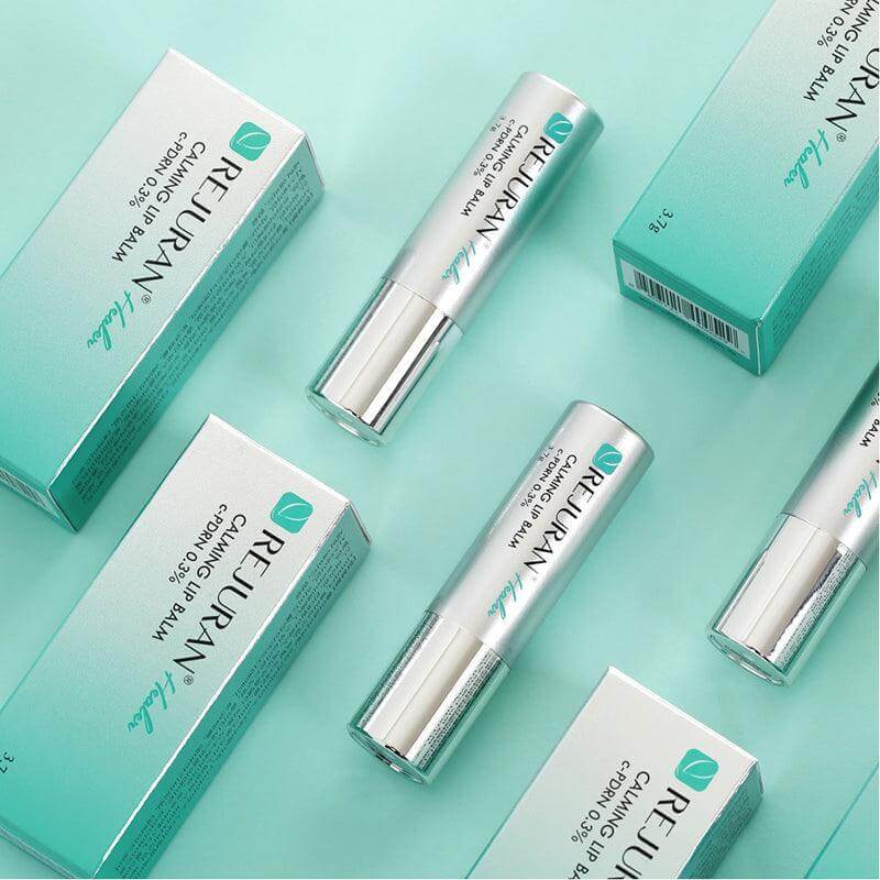 REJURAN Healer Calming Lip Balm 3.7g tubes and packaging on a teal background