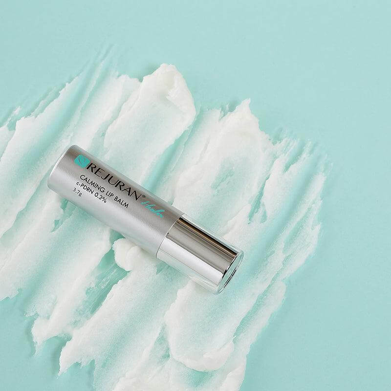 REJURAN Healer Calming Lip Balm 3.7g on textured background