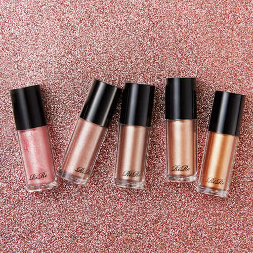 Assorted shades of RIRE Luxe Liquid Shadow on a glittery background.