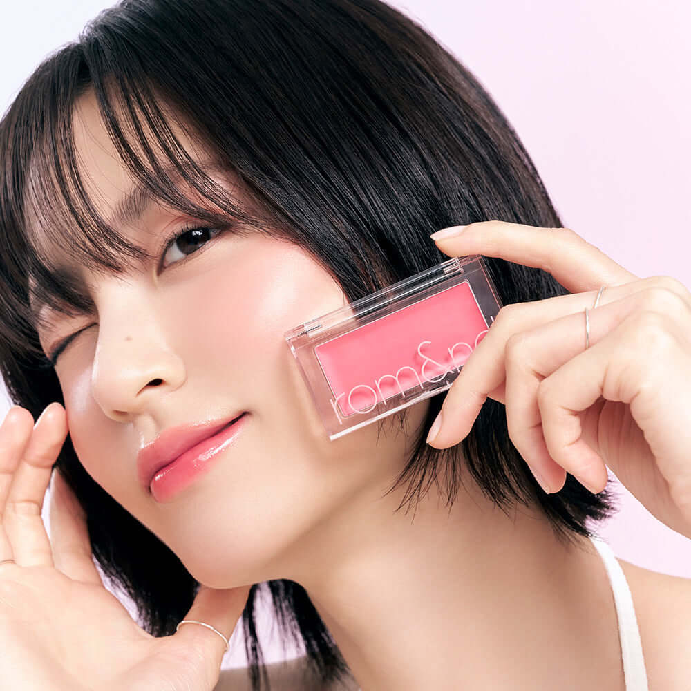 Person holding ROMAND better than cheek #glaze, showcasing pink blush.