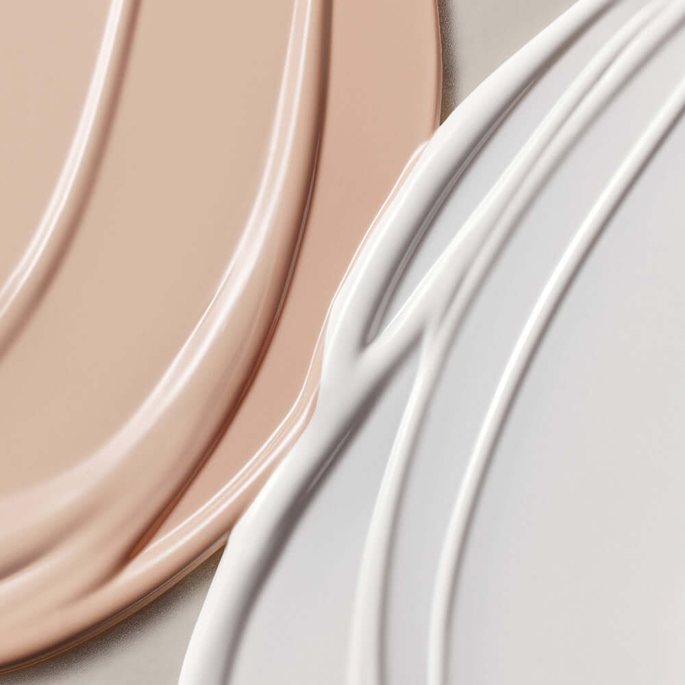 Close-up texture of ROMAND white me tone up sun cushion in two shades showing smooth application and finish.