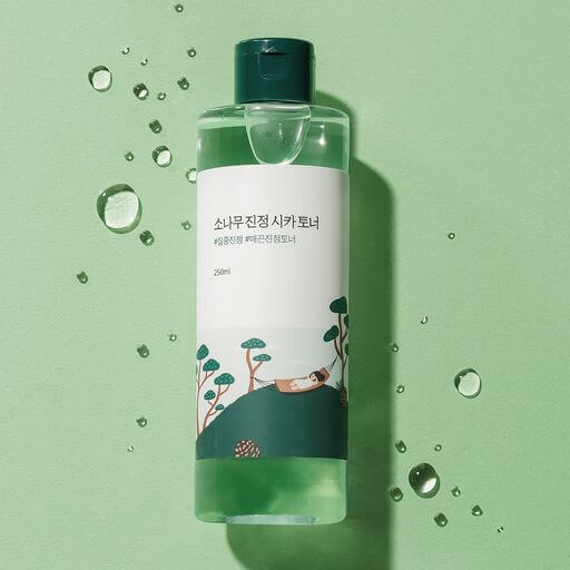 ROUND LAB Pine Calming Cica Toner 250ml bottle on green background with water droplets