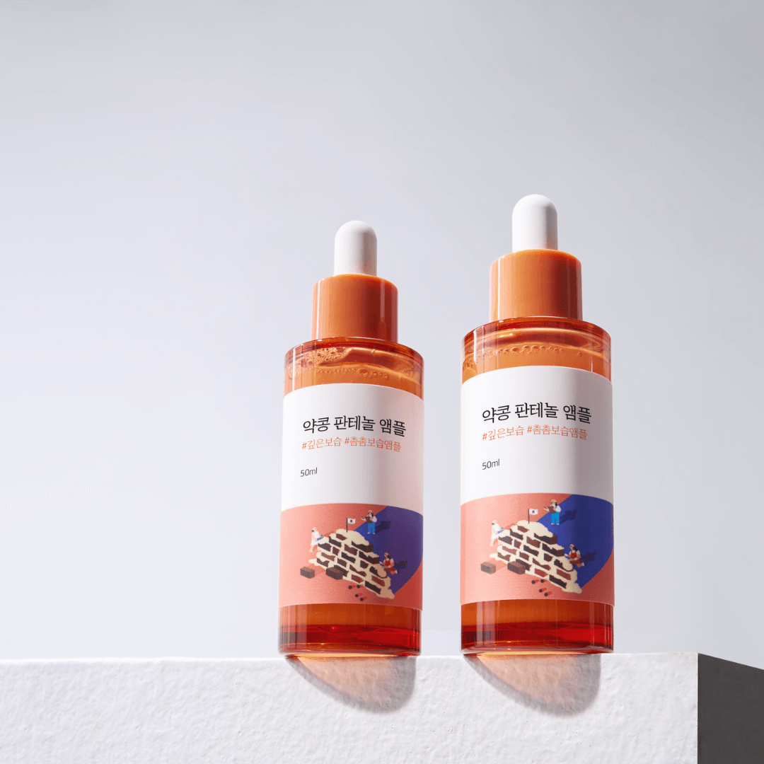 Two bottles of ROUND LAB Pine Calming Cica Ampoule 30ml displayed on a white surface, showcasing skincare packaging.