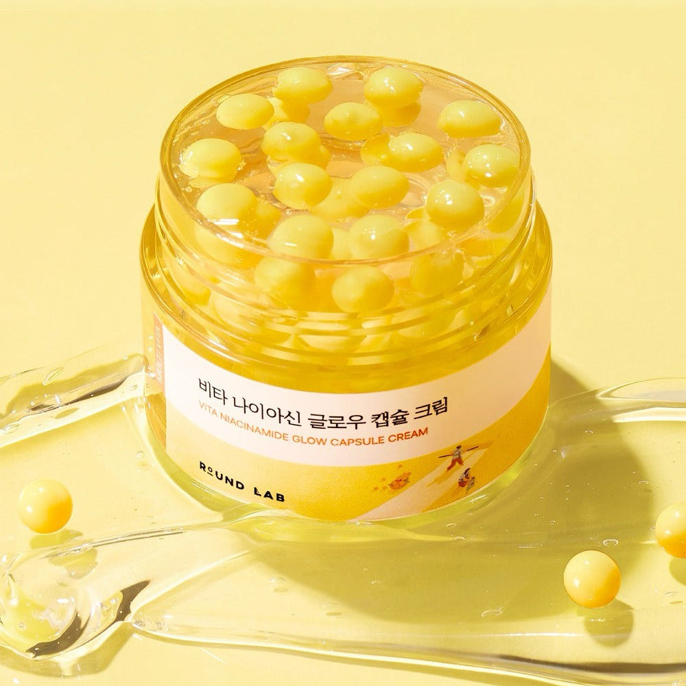 ROUND LAB Vita Niacin Glow Capsule Cream 50ml on yellow background with capsule details.