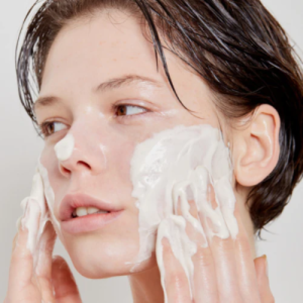 Woman applying SKIN1004 Madagascar Centella Tea-trica BHA Foam 125ml on face