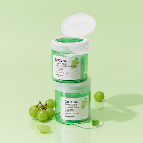 Two SKINFOOD CICA BHA Toner Pad containers with green grapes and mint leaves on a light green background.