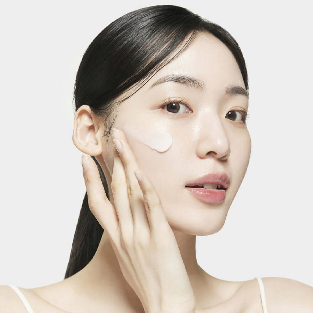 Woman applying SU:M37 Microactive Pink Vitamin Bubble Tox Mask 4ml (14 sheet) on her cheek