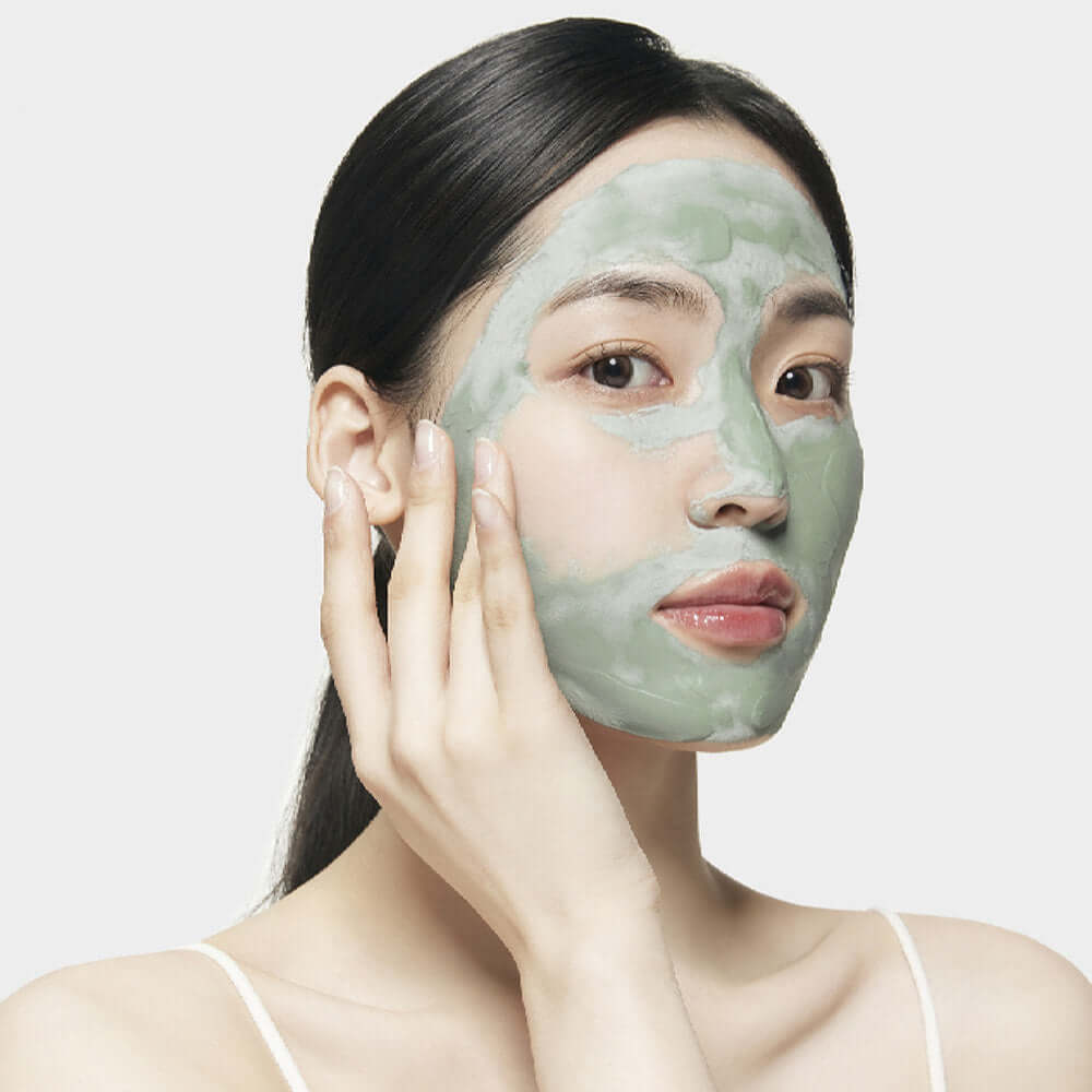 Woman applying SU:M37 Microactive Super Matcha Pore Mask 100ml to face for skincare routine