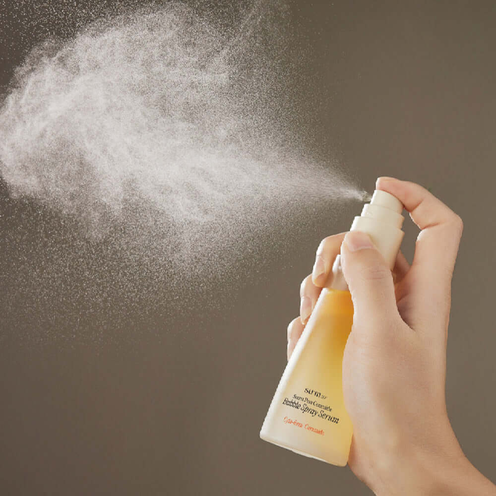 Person spraying SU:M37 Secret Pore Ceramide Bubble Oil Essence Mist 60ml, showcasing fine mist in action.